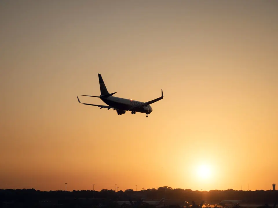 An airliner on approach against the setting sun